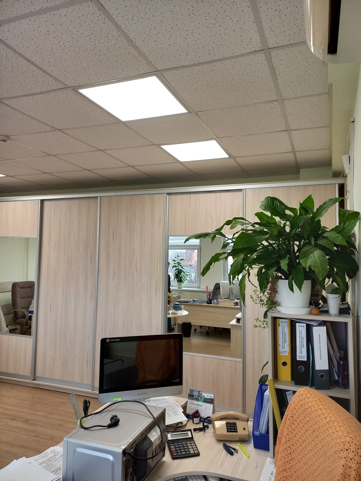 Рабочий стол с цветами на фоне шкафа-купе